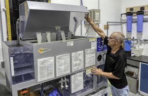 Techevon LLC employee working with a hooded machine