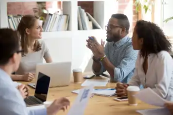 Four workers sitting around a table having a meeting