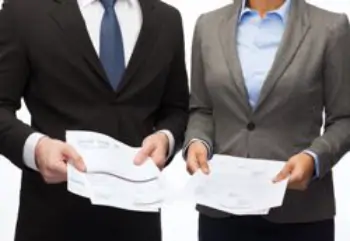 Two businesspeople comparing documents in their hands