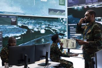 Military soldier transmitting information from satellite displays on phone call, supporting field missions with crucial intelligence.