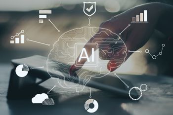 Close up of hand using tablet with AI showing an outline of a brain with chart and gear images